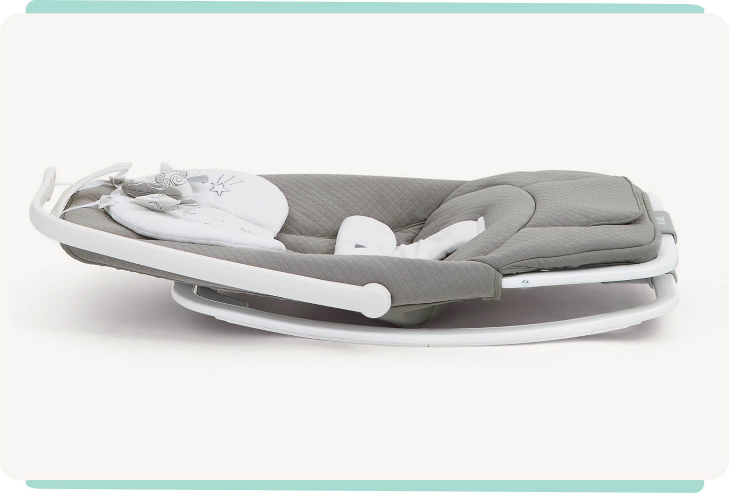 Grey patterned dreamer Joie bouncer lying flat on the ground to display compact feature.