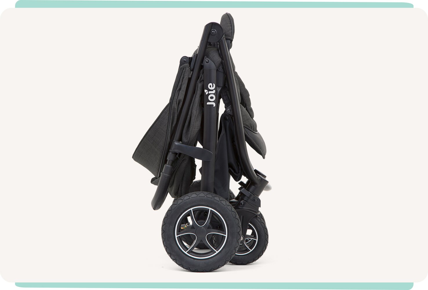  A black Joie Mytrax Flex stroller folded, from a side view.