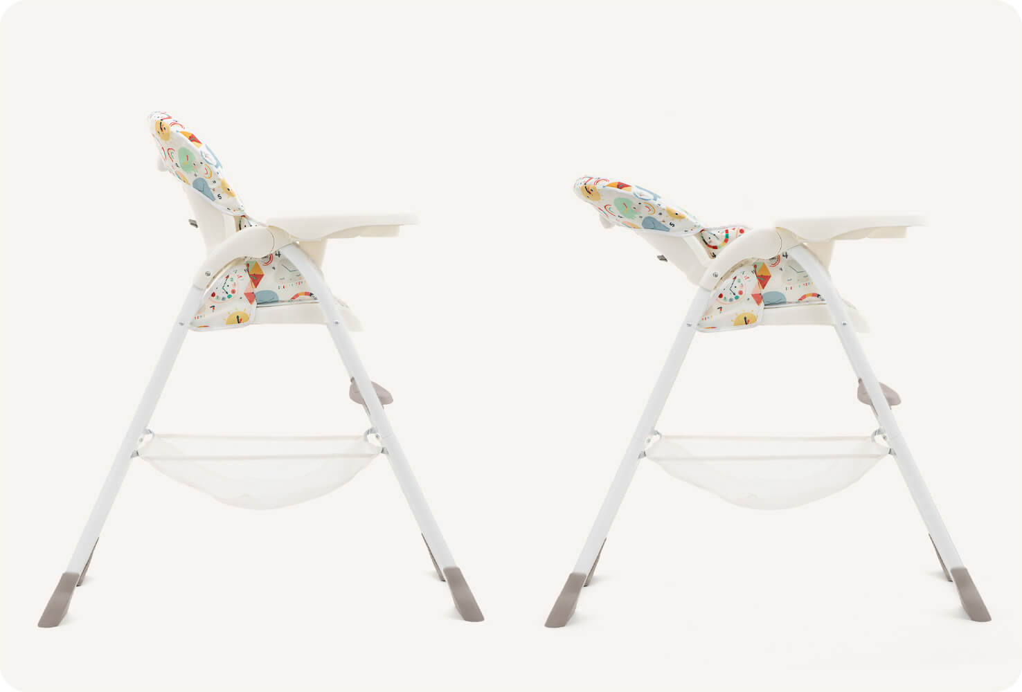  Deux chaises hautes Joie dans un imprimé multicolore représentant des cadrans d’horloges, animaux et formes géométriques de dessin animé, en vue latérale. L’une est en position verticale, l’autre en position inclinée pour indiquer la fonction d’inclinai