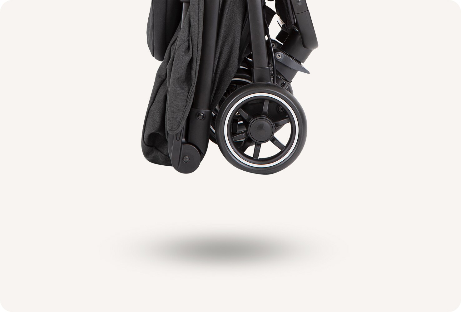  A folded Pact Flex stroller floating above the ground.