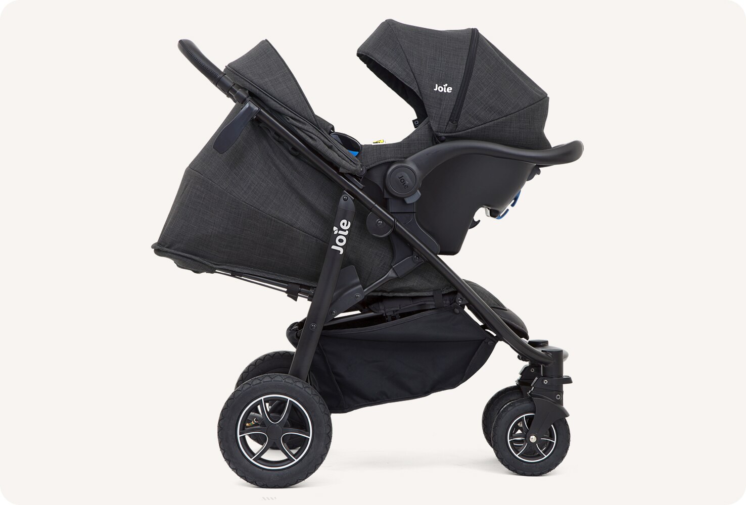  A black Joie Mytrax Flex stroller with matching infant car seat attached, from a side view.