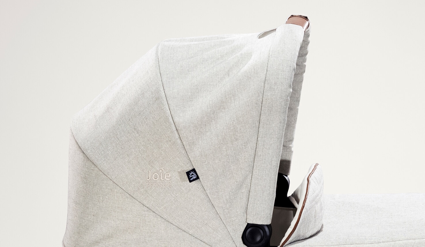 Close-up side view of the raised hood on the Joie Signature ramble carry cot in light gray.