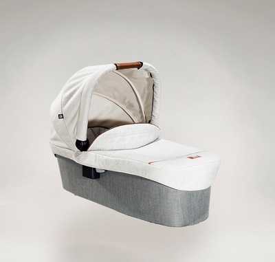 Joie Signature ramble carry cot in light gray at a right angle with hood raised.